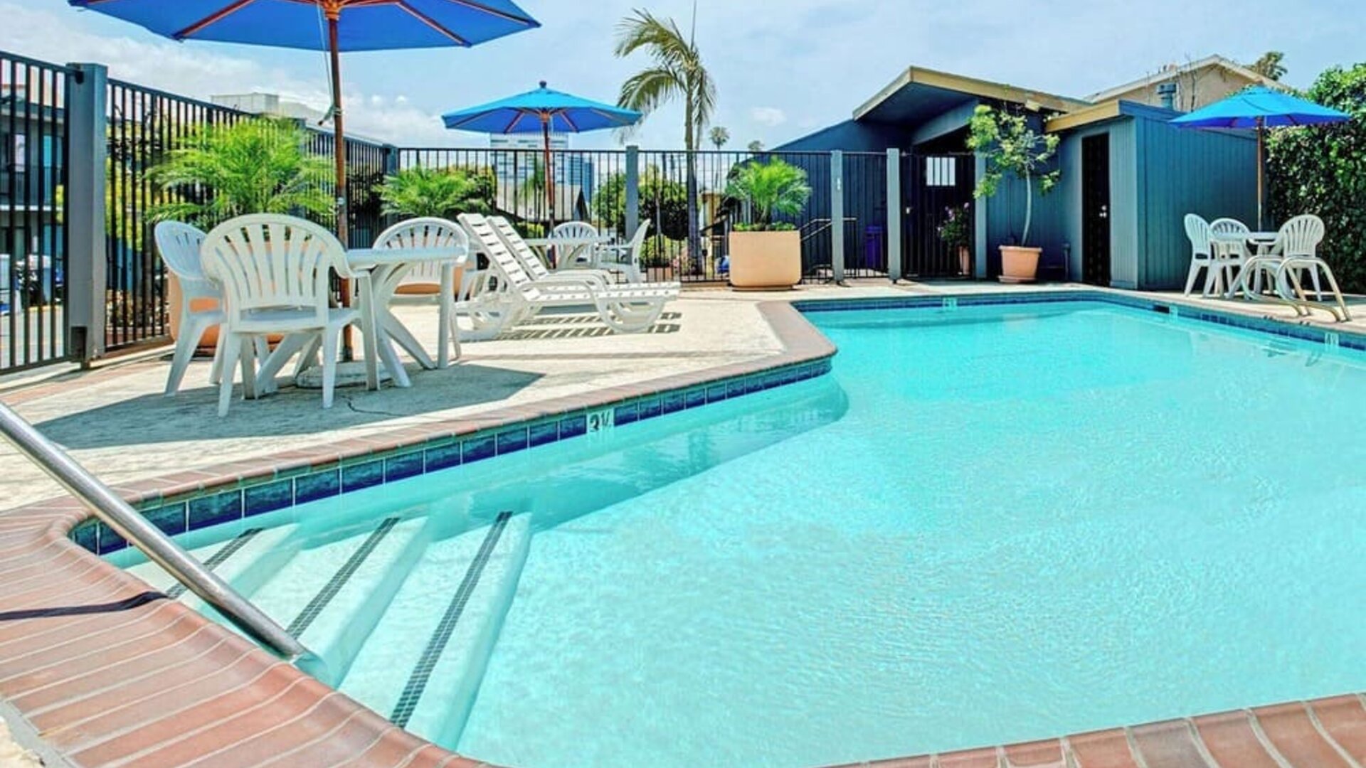 Outdoor pool with lounge chairs at Travelodge LAX By Wyndham.