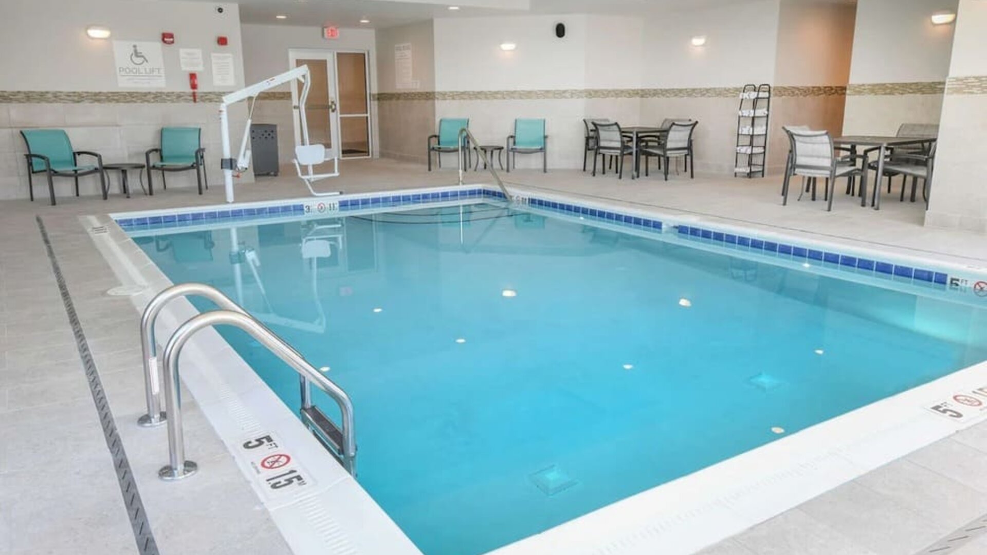 Indoor pool with lounge chairs at Hilton Garden Inn Cincinnati Midtown.