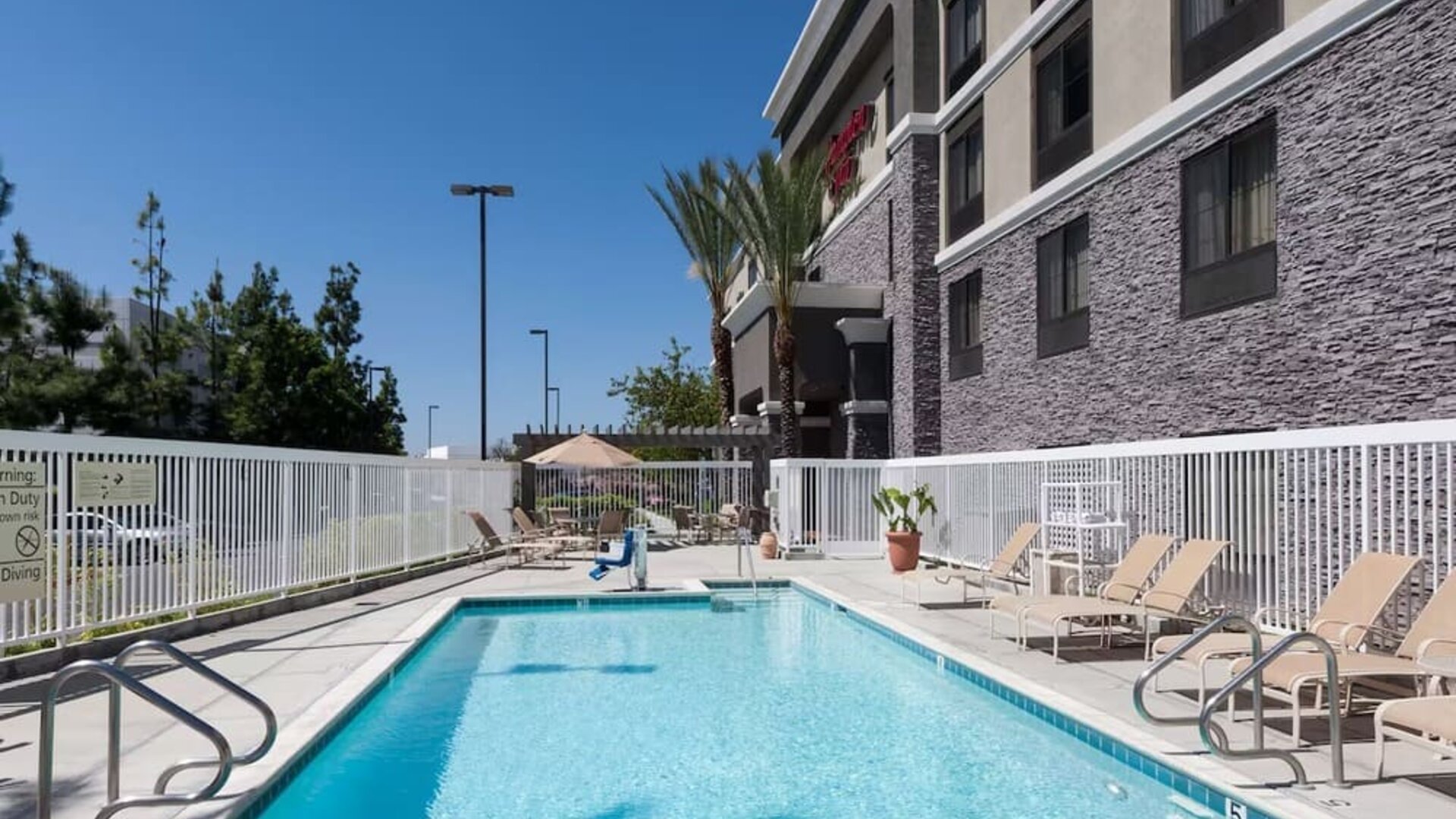Outdoor pool with lounge chairs at Hampton Inn Los Angeles-Orange County-Cypress.