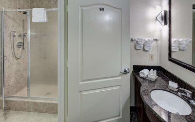 Private guest bathroom with shower and free toiletries at Homewood Suites By Hilton Agoura Hills.