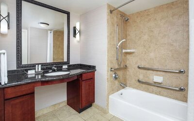 Private guest bathroom with combined shower and tub at Homewood Suites By Hilton Agoura Hills.