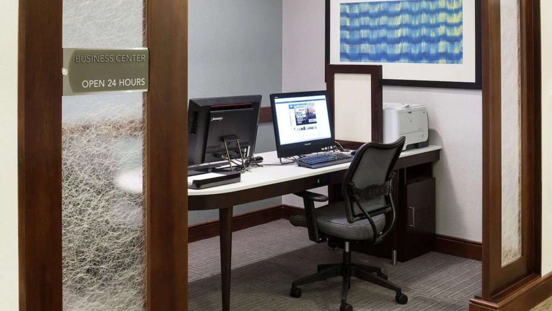 Business center with computers, printer and ergonomic chairs at Homewood Suites By Hilton Agoura Hills.