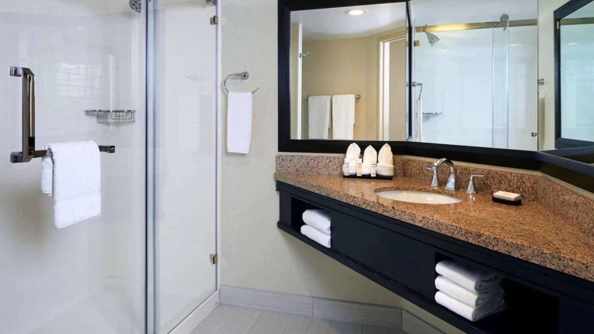Private guest bathroom with shower and free toiletries at Embassy Suites By Hilton Los Angeles-Intl Airport North.