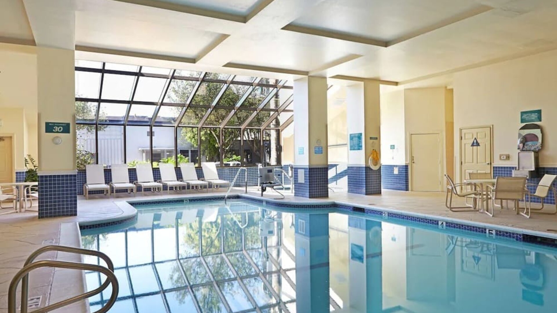 Relaxing indoor pool with lounge chairs at Embassy Suites By Hilton Los Angeles-Intl Airport North.