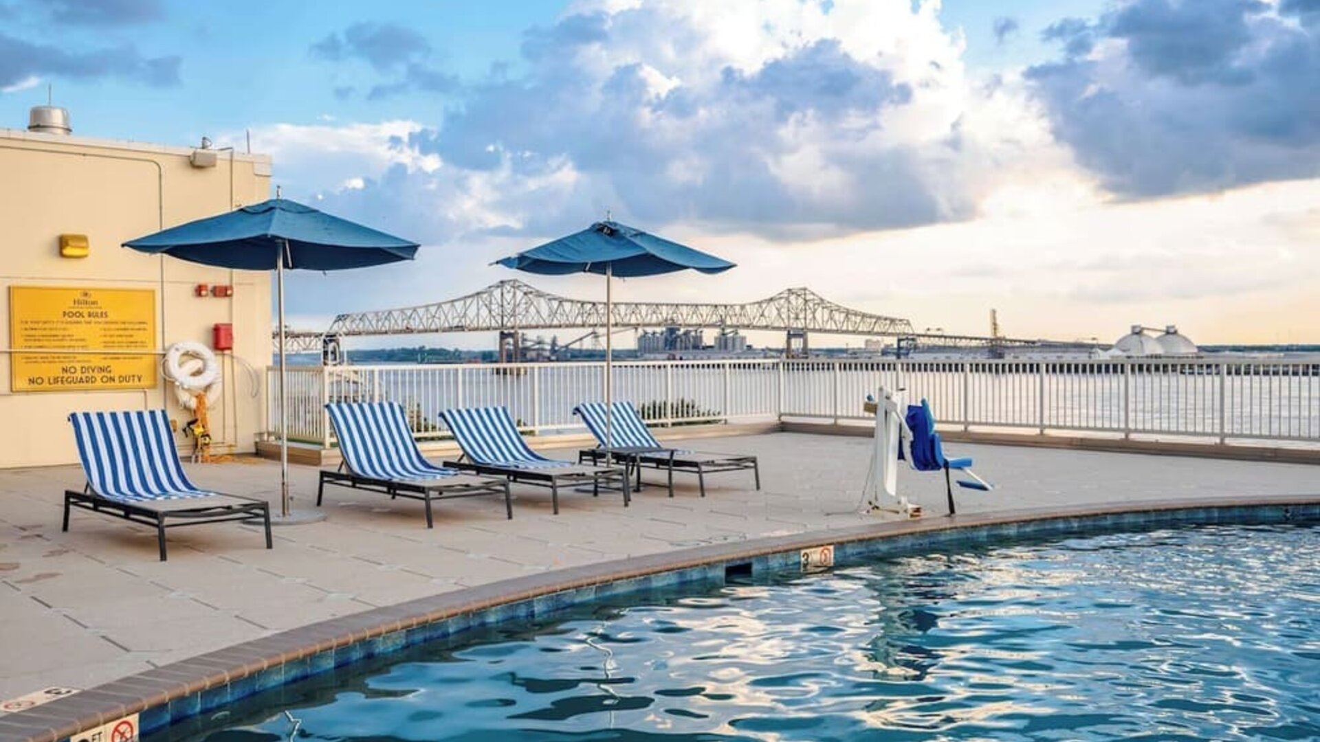 Outdoor pool with lounge seating and great city view at Hilton Baton Rouge Capitol Center.