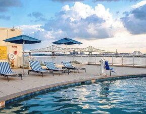 Outdoor pool with lounge seating and great city view at Hilton Baton Rouge Capitol Center.