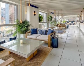 Rooftop bar and dining area with natural light at Hilton New York Fashion District.