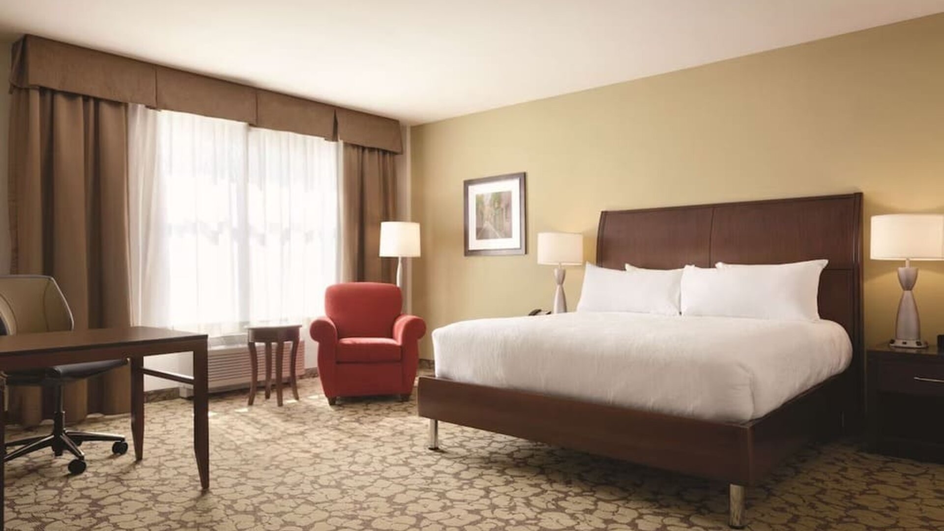 Spacious delux king bed with TV and work desk at Hilton Garden Inn Boston Logan Airport.