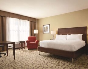 Spacious delux king bed with TV and work desk at Hilton Garden Inn Boston Logan Airport.