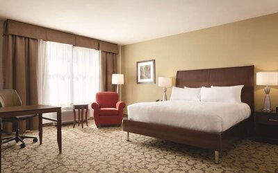 Spacious delux king bed with TV and work desk at Hilton Garden Inn Boston Logan Airport.