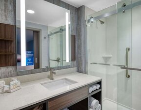 Private guest bathroom with shower at Hilton Garden Inn Boston Logan Airport.