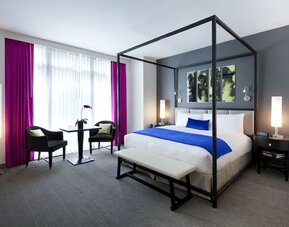 King bedroom with seating area and natural light at Royalton Park Avenue.