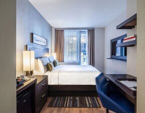 Day use room with work desk and balcony at The Bernic Hotel New York City, Tapestry Collection By Hilton.
