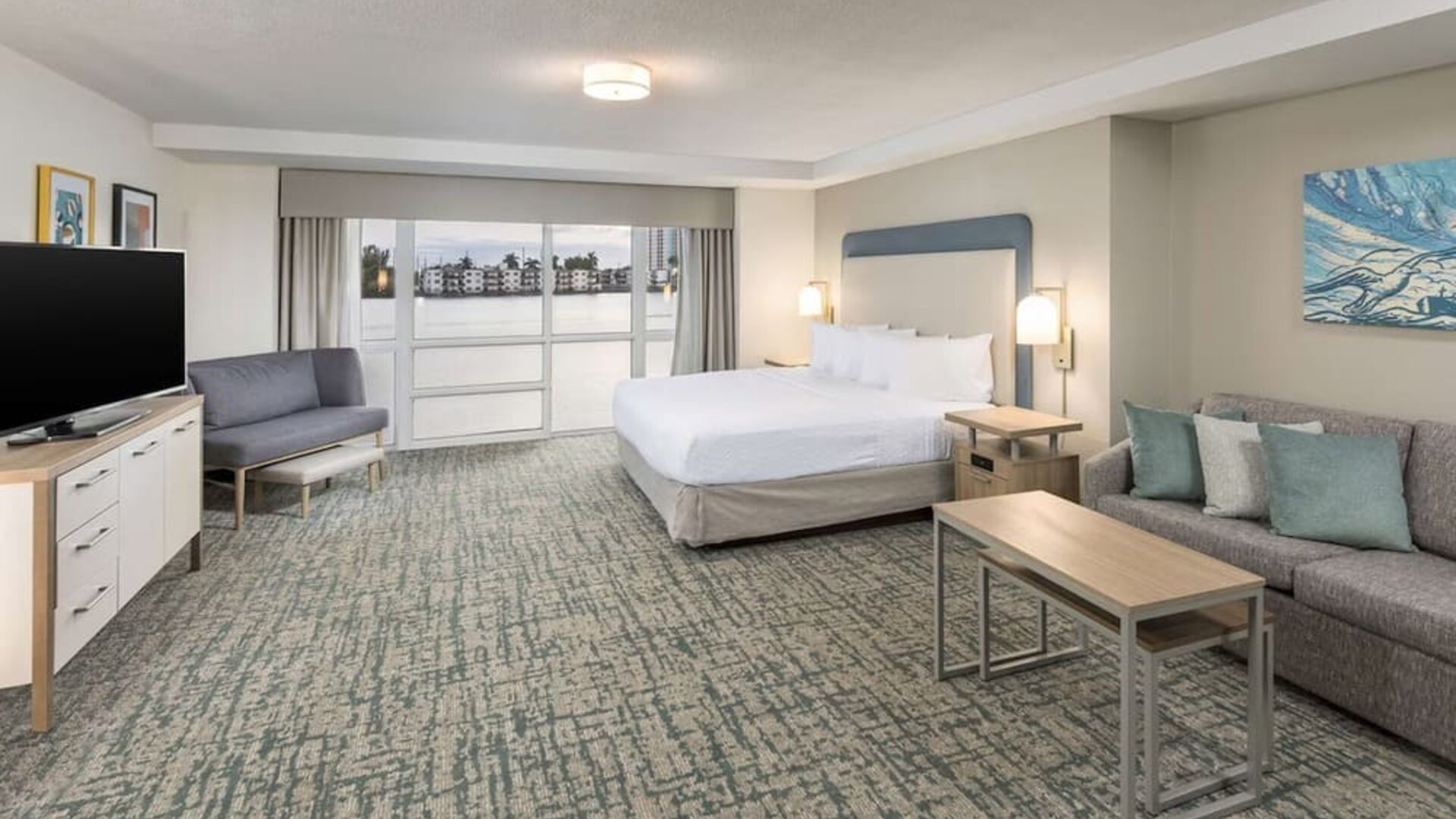 Spacious day use room with sofa and a view of the Blue Lagoon at Homewood Suites By Hilton Miami Airport-Blue Lagoon.