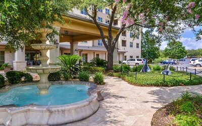 Hotel facade and the parking area at Hilton San Antonio Hill Country.
