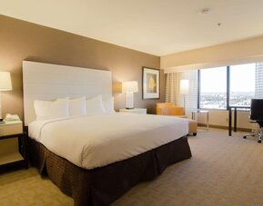 Delux king room with work desk and natural light at Hilton Los Angeles Airport.