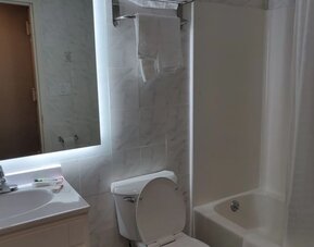 Guest bathroom with shower and tub at Hotel Key.