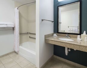 Private guest bathroom with combined shower and tub at Hilton Garden Inn Dothan.