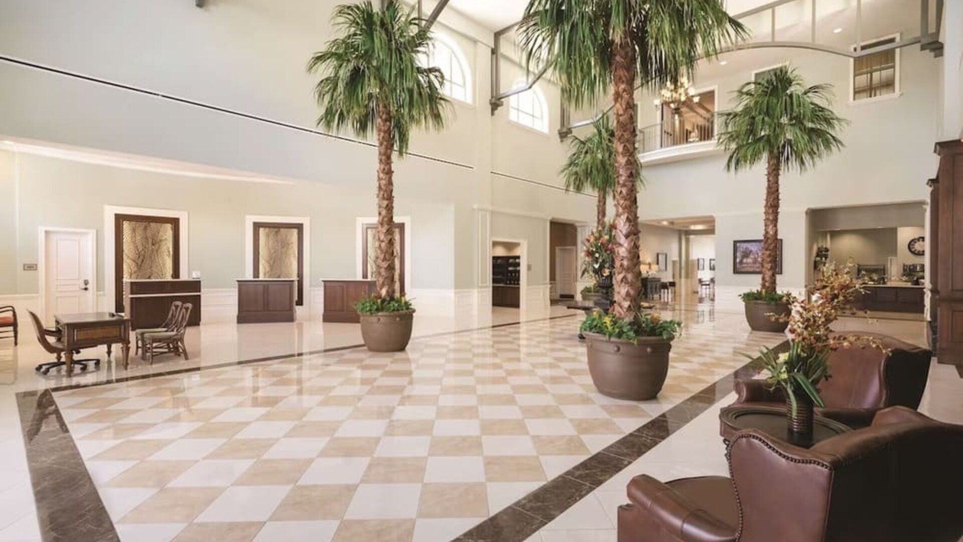 Hotel reception with lounge seating and workspace at Embassy Suites By Hilton Savannah.