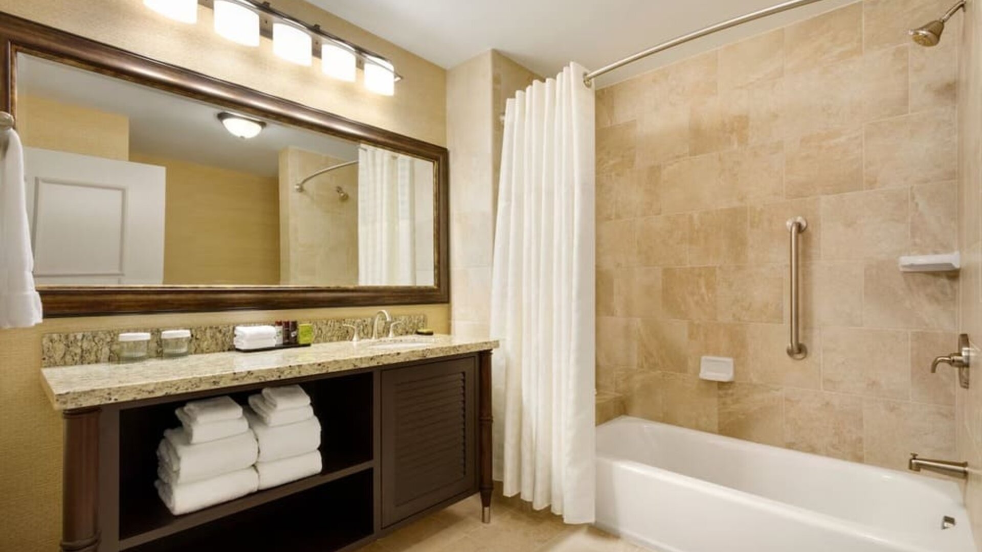 Private guest bathrooom with combined shower and tub at Embassy Suites By Hilton Savannah.
