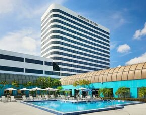 Outdoor pool with lounge chairs at Embassy Suites By Hilton West Palm Beach Central.
