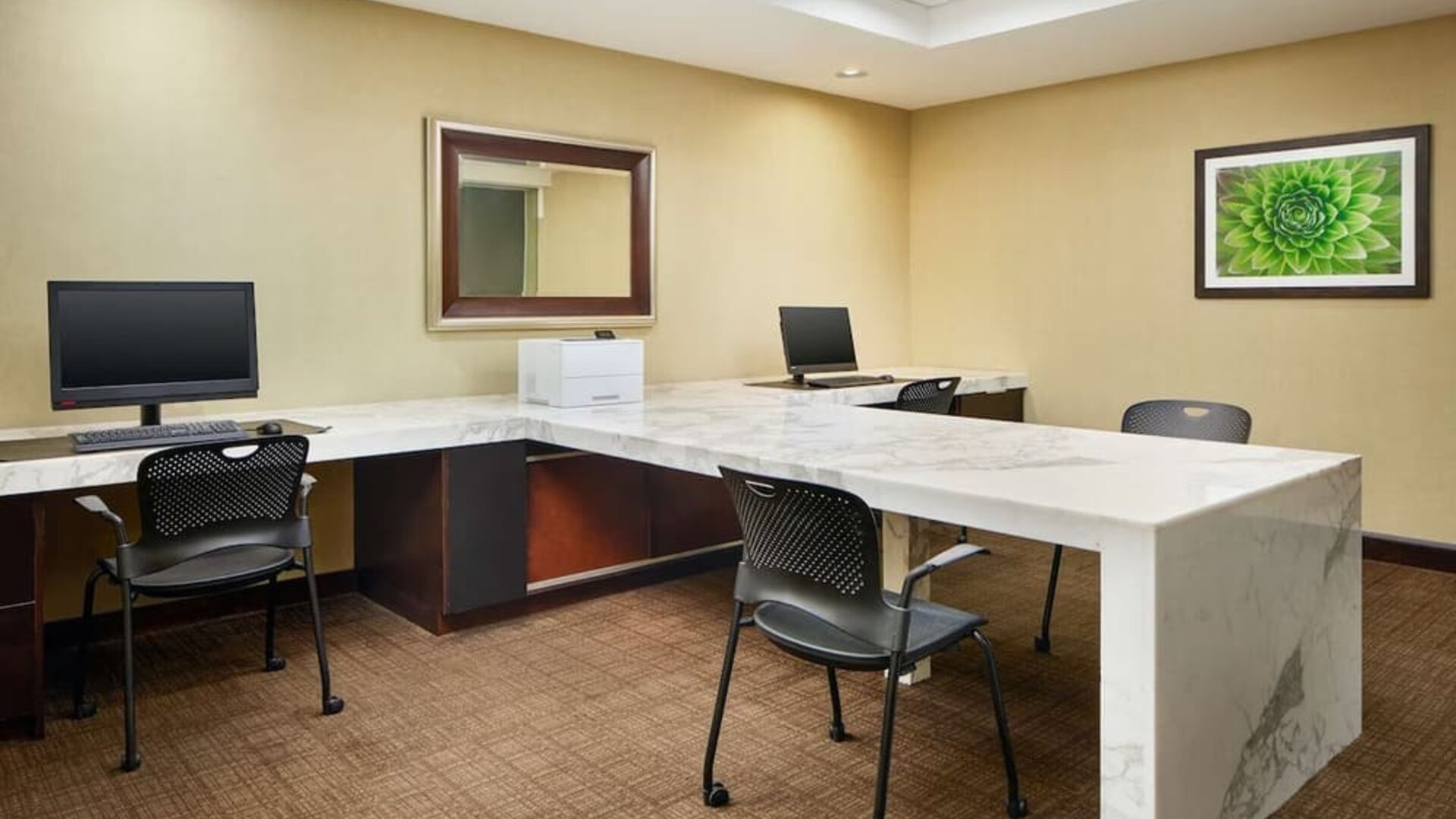 Business center with computers, printer and comfortable seating at Embassy Suites By Hilton West Palm Beach Central.