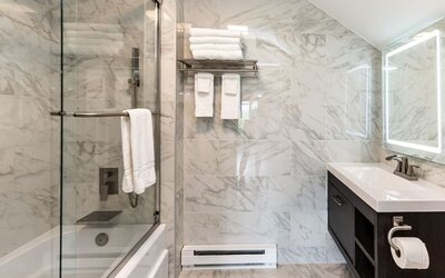 Private guest bathroom with combined shower and tub at SKYLARANNA Resort & Spa.