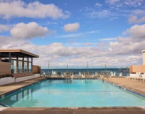 Outdoor pool with lounge chairs at Sea Crest Beach Hotel.