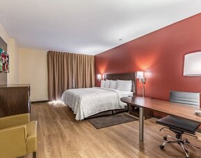 Spacious delux king bedroom with work desk at Red Roof PLUS+ & Suites Houston - IAH Airport SW.