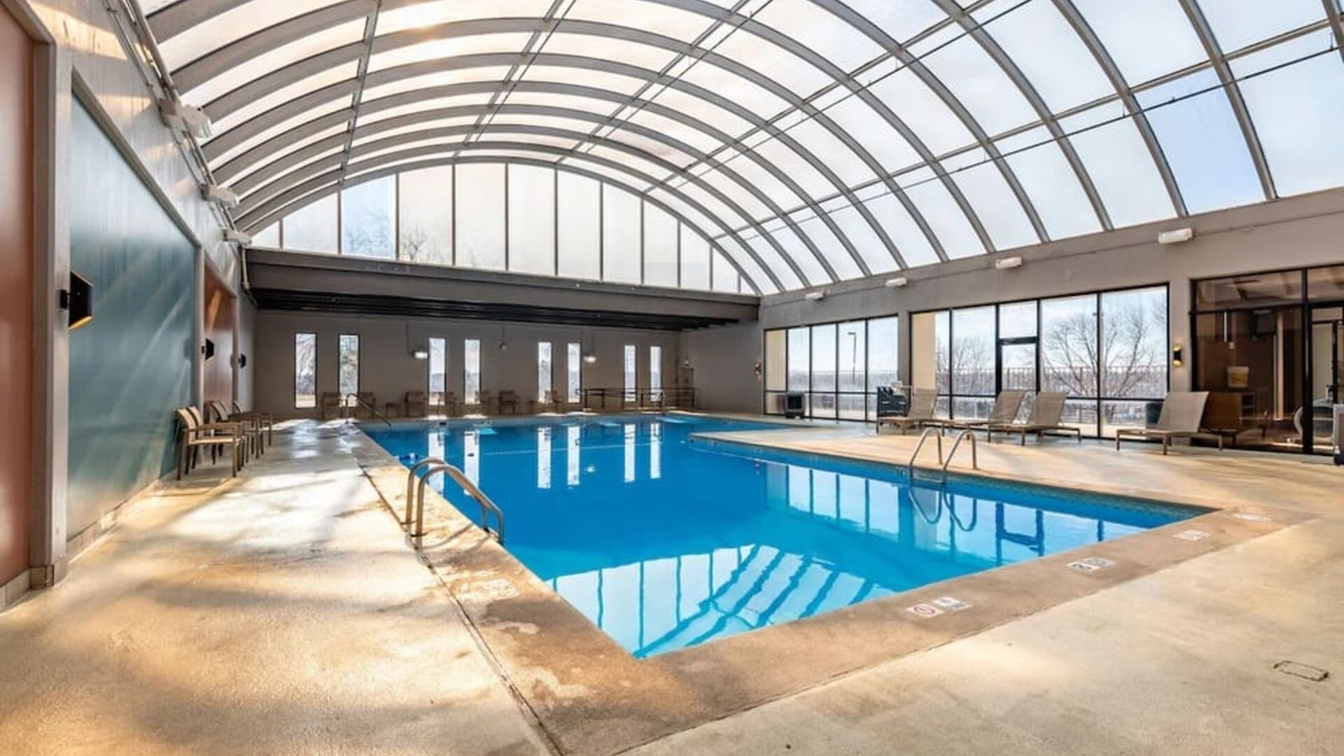 Relaxing indoor pool with lounge chairs at Wyndham Omaha.