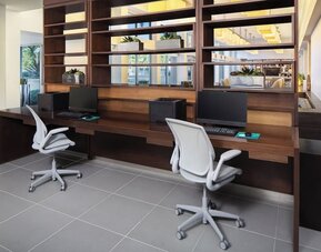Business center with computers, printer and ergonomic chairs at Element Miami International Airport.