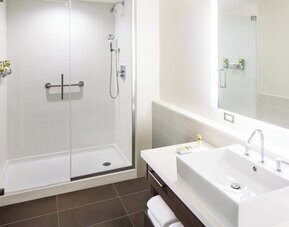 Private guest bathroom with shower and free toiletries at Element Miami International Airport.