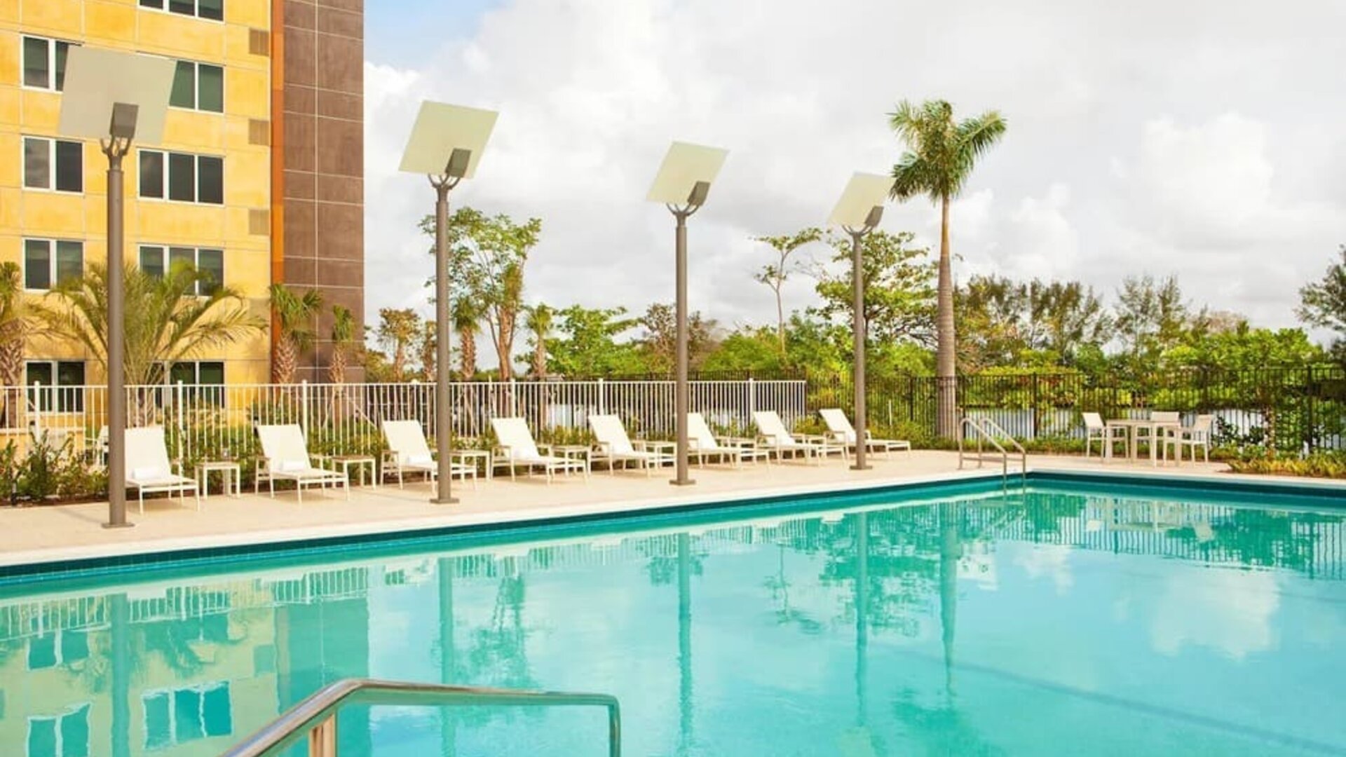 Outdoor pool with lounge chairs at Element Miami International Airport.