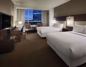 Day use twin room with workspace and lounge seating at Hilton Dallas/ Plano Granite Park.