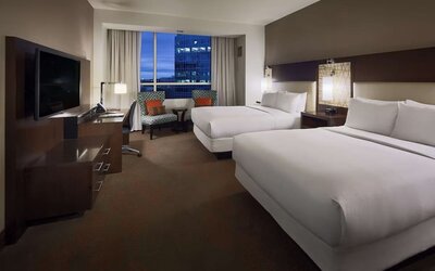 Day use twin room with workspace and lounge seating at Hilton Dallas/ Plano Granite Park.