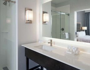 Guest bathroom with shower at Homewood Suites By Hilton LAX Airport.