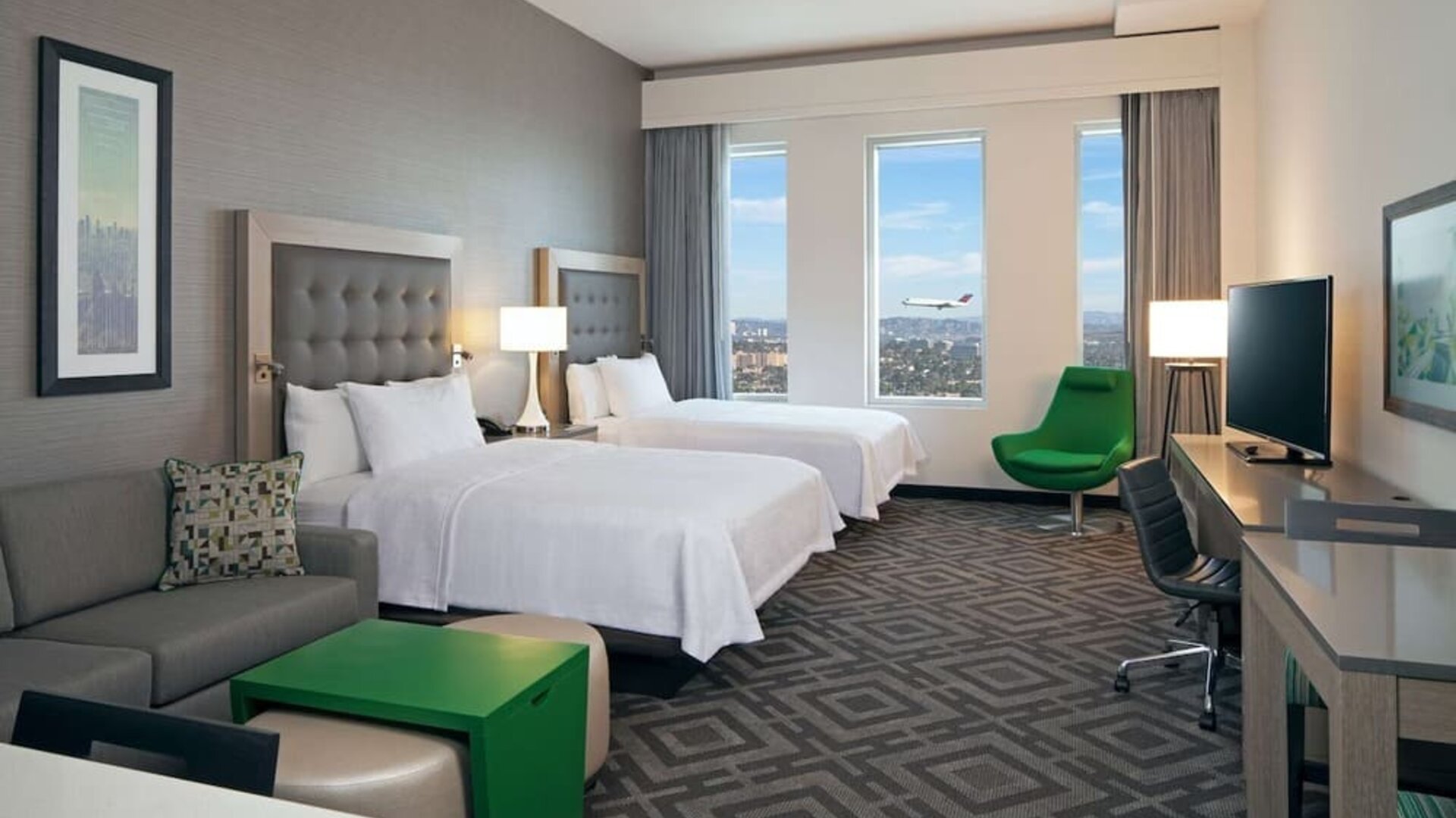 Twin bedroom with work desk and sofa at Homewood Suites By Hilton LAX Airport.