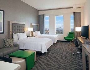 Twin bedroom with work desk and sofa at Homewood Suites By Hilton LAX Airport.