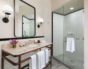 Private guest bathroom with shower at The Candler Hotel Atlanta, Curio Collection By Hilton.
