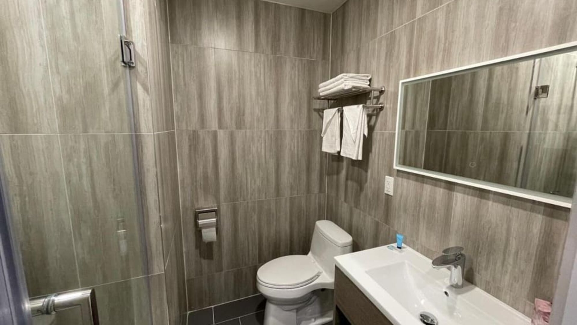 Private guest bathroom with shower and free toiletries at King Hotel Brooklyn.