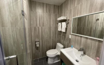 Private guest bathroom with shower and free toiletries at King Hotel Brooklyn.