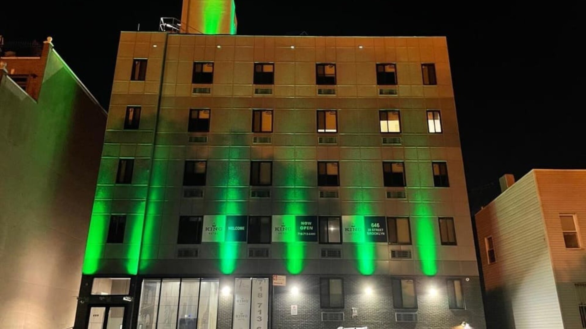 Exterior of King Hotel Brooklyn and parking area,