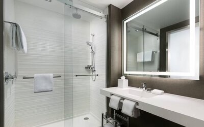 Private guest bathroom with shower and free toiletries at AC Hotel New York Times Square.