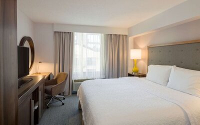 Day use room with king bed, work desk, natural light and private bathroom at Hampton Inn Manhattan Chelsea.