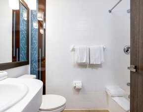 Private guest bathroom with combined shower and tub at Regency Miami Airport By Sonesta.