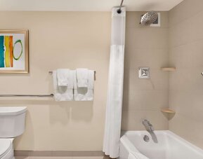 Private guest bathroo with combined shower and tub at Hilton Miami Airport Blue Lagoon.
