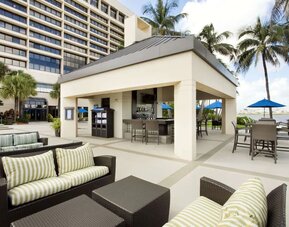 Hotel terrace with lounge seating at Hilton Miami Airport Blue Lagoon.