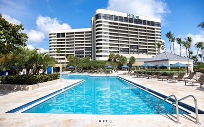 Outdoor pool with lounge seating at Hilton Miami Airport Blue Lagoon.