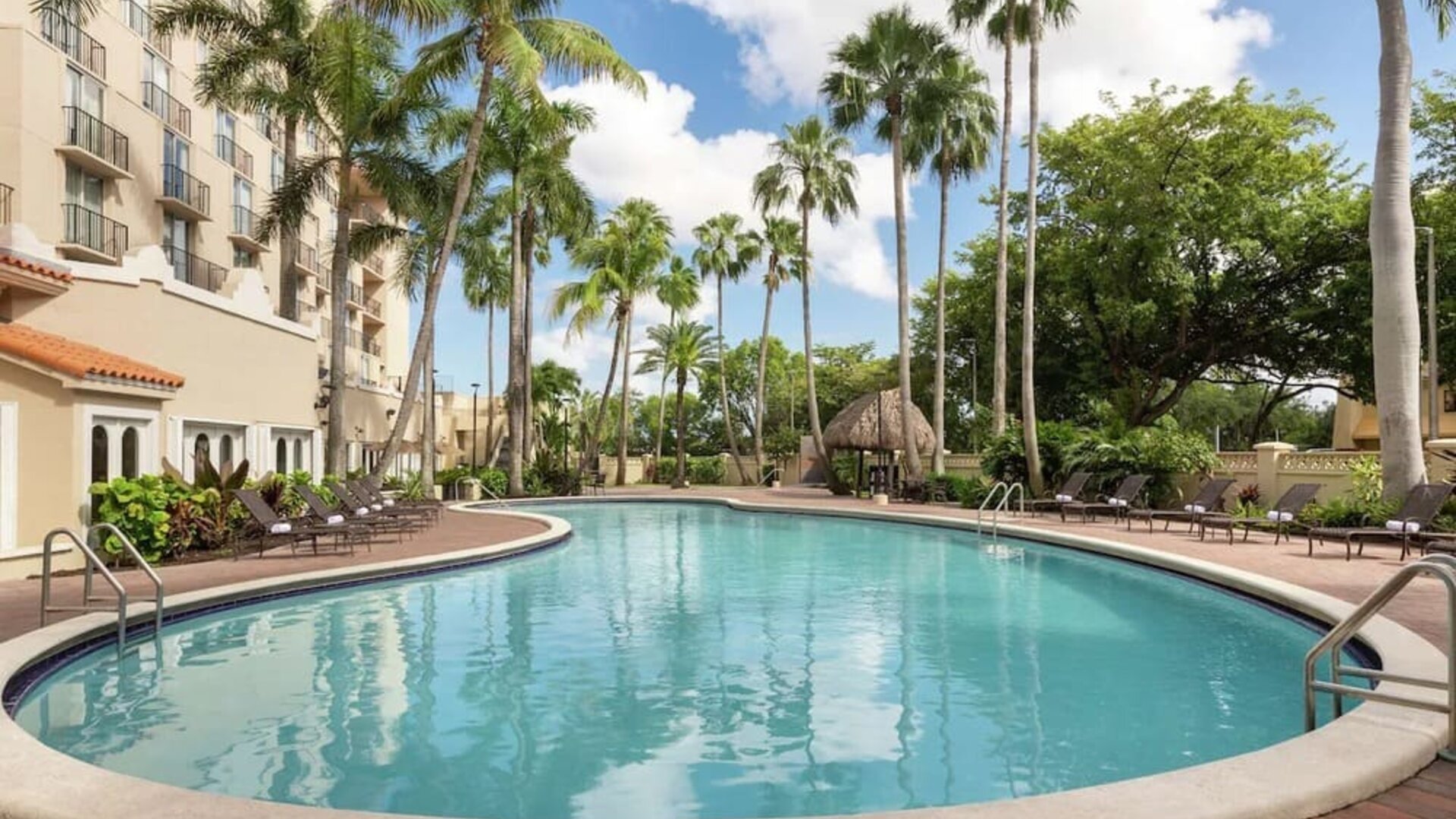 Beautiful outdoor pool with lounge chairs at Embassy Suites By Hilton Miami - International Airport.