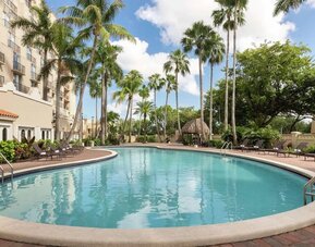 Beautiful outdoor pool with lounge chairs at Embassy Suites By Hilton Miami - International Airport.